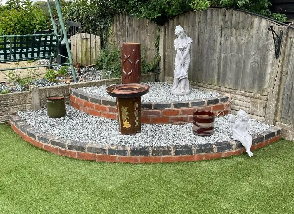 Curved brick planter with gravel and lawn