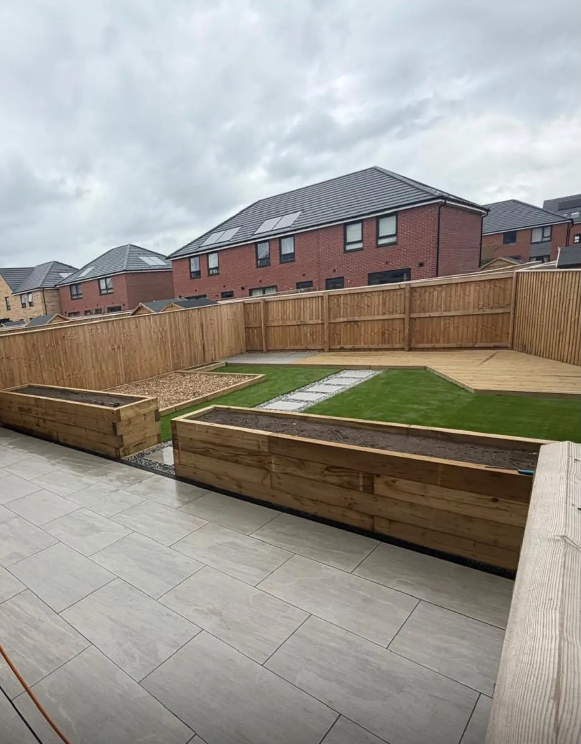 Timber raised planters, bark play square, lawn and decking