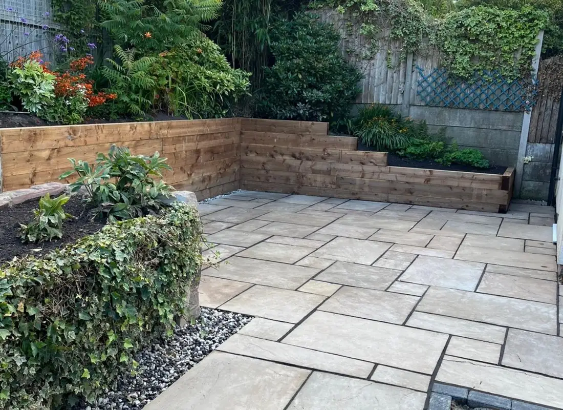 Stone patio with timber sleeper retaining walls