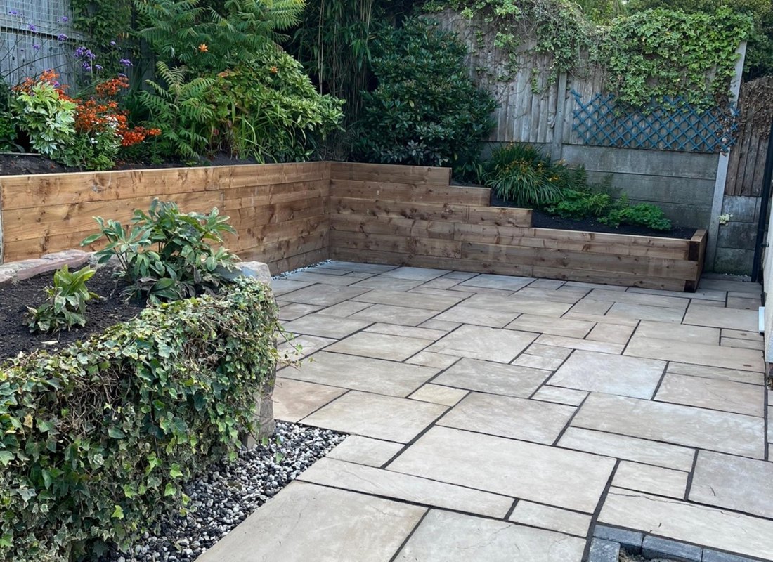 Stone patio with timber sleeper retaining walls